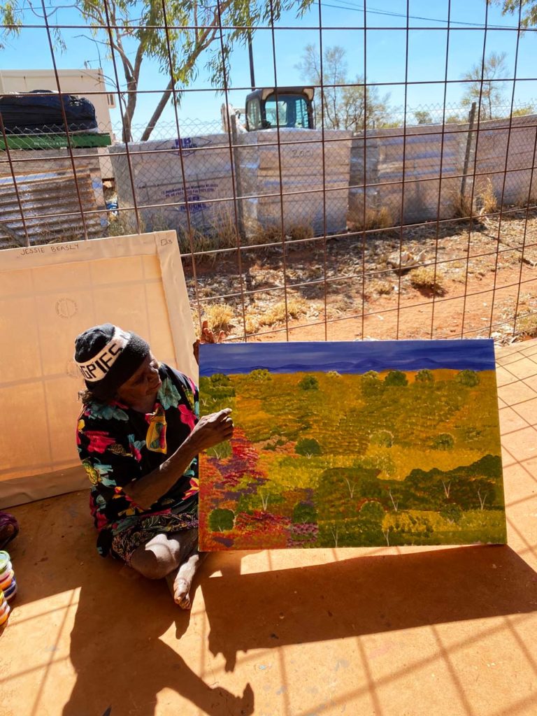 Epenarra Artist, Ada Beasley explaining how flowers bloom after bush fire as depicted in her painting - Barkly Regional Arts